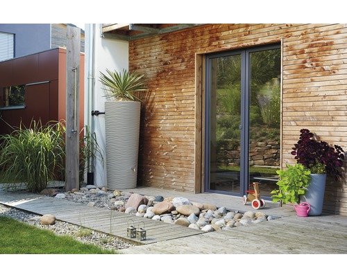 Buitenruimte met regenton, houten wand en tuindouche.