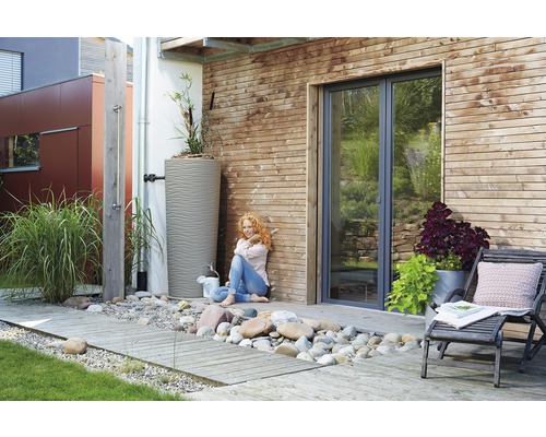 Tuin met regenwatertank, buitendouche en houten terras.