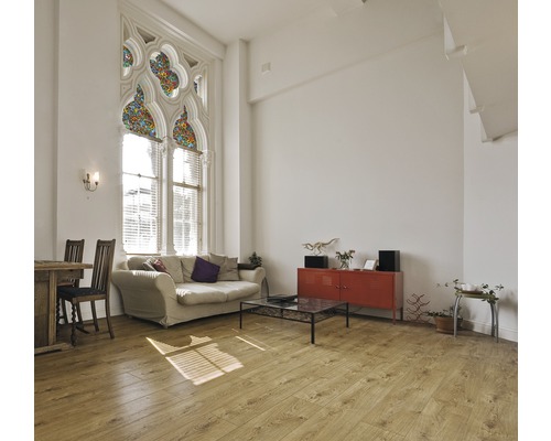 Lichte woonkamer met bank, tafel, stoelen, dressoir en groot raam