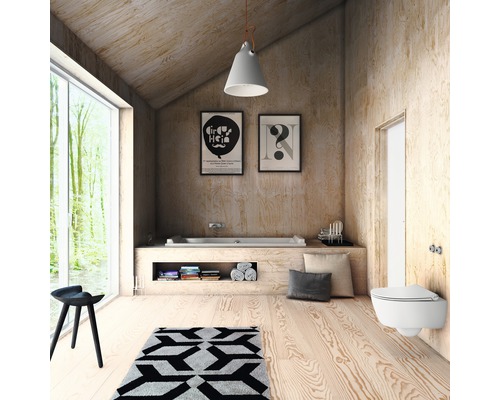 Badkamer met ligbad, toilet, kruk, tapijt en decoratie in licht houten design