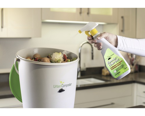 Compostemmer met organisch afval en spuitfles voor compostversneller in de keuken