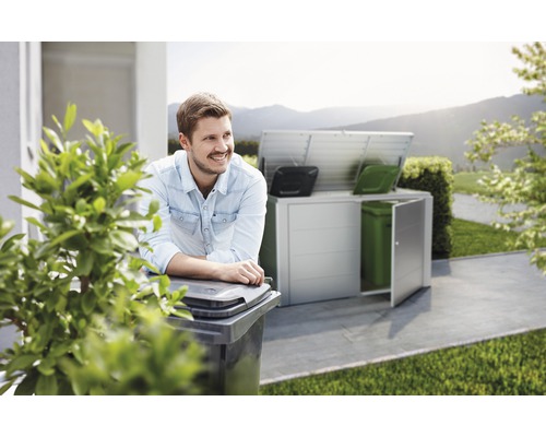 Scène met een man die leunt op een vuilnisbak en een vuilnisbakopslag op de achtergrond.