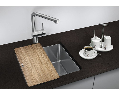 Spoelbak met snijplank, kraan en koffieservies op een aanrecht