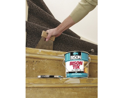 Aanbrengen van tapijtlijm op een trap met een plamuurmes