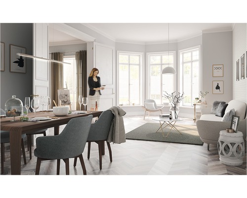 Lichte woonkamer met eettafel, stoelen, bank en decoraties in een vriendelijke sfeer.