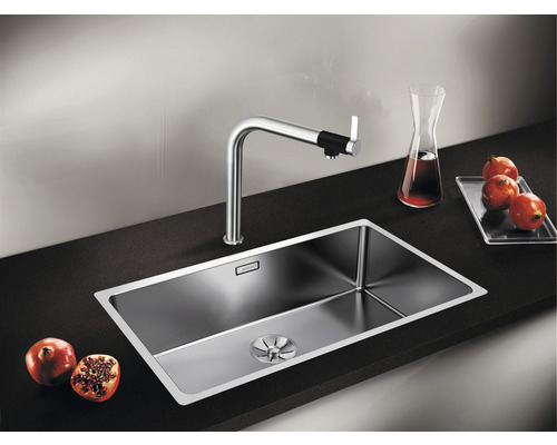 Roestvrijstalen spoelbak met kraan op een donker aanrechtblad