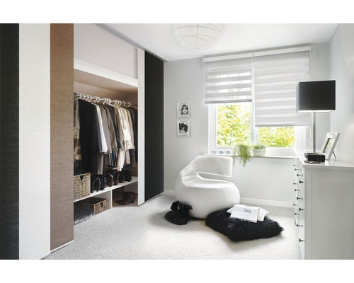 Lichte slaapkamer met schuifdeurkast, rolgordijn en moderne fauteuil