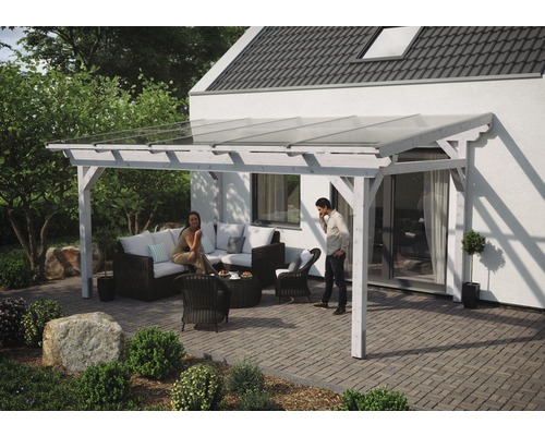 Overdekt terras met houten balken, glazen dak en zithoek in de tuin.