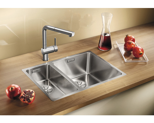 Roestvrijstalen spoelbak met twee bakken en kraan op een houten aanrechtblad