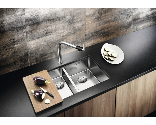 Keuken spoelbak met kraan, snijplank en aubergine op een werkblad