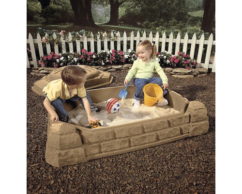 Zandbak met twee kinderen, zandspeelgoed en deksel in de tuin.