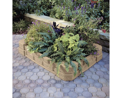 Betonnen border met planten in een tuin.