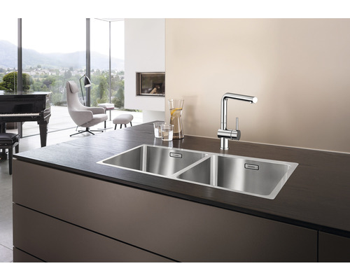 Roestvrijstalen spoelbak met twee bakken en kraan op een werkblad.