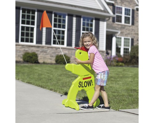 Kind omhelst een groen verkeersbord met het opschrift ''Langzaam!'' en een oranje vlag