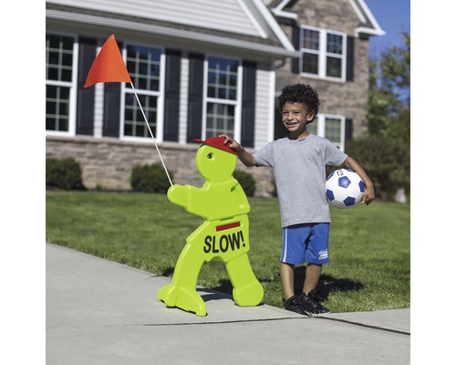 Verkeersbord met de tekst Langzaam en een jongen met een voetbal