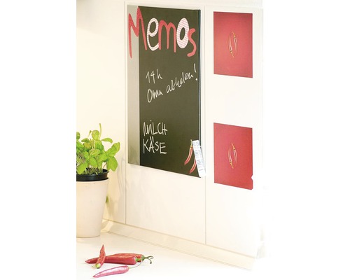 Memobord naast koelkastmagneten aan keukenmuur