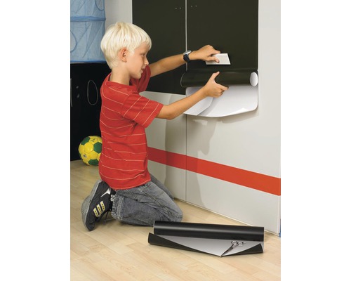 Jongen brengt decoratieve folie aan op een kast