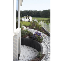 Tuinscene met tuinhuis, pad van straatstenen en decoratieve borderbegrenzing