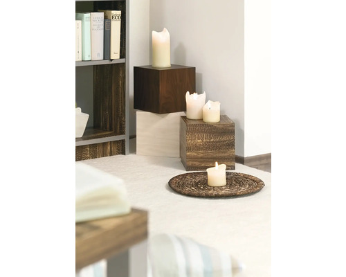 Decoratieve opstelling met kaarsen op houten sokkels en een onderzetter