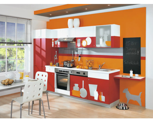 Lichte keuken met keukenmeubels in wit en rood, eettafel met stoelen en decoratie.