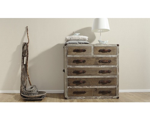 Houten commode met meerdere laden en lederen handgrepen, aangevuld met een lamp en decoratieve elementen.