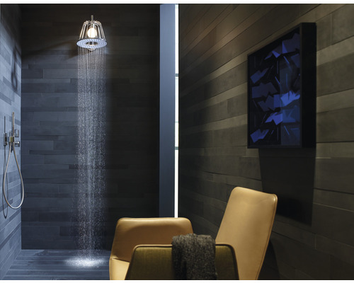 Badkamer met douche, douchekop, betegelde muur, stoel en kunstwerk