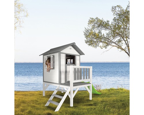 Houten speelhuis met glijbaan in de tuin