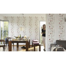 Lichte eetkamer met eettafel, stoelen, bank en behang met bloemenmotief