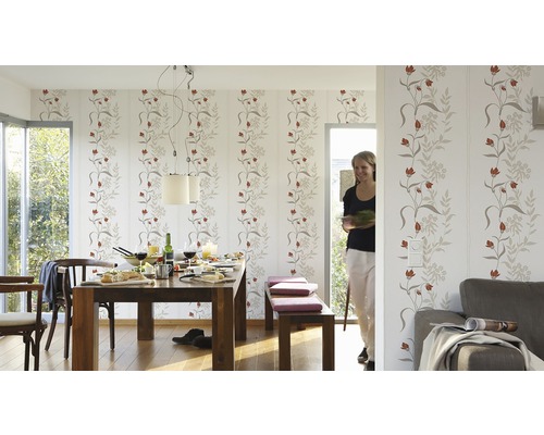 Lichte eetkamer met eettafel, stoelen, bank en behang met bloemenmotief