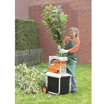 Vrouw bedient een Atika tuinhakselaar voor het versnipperen van takken en groenafval