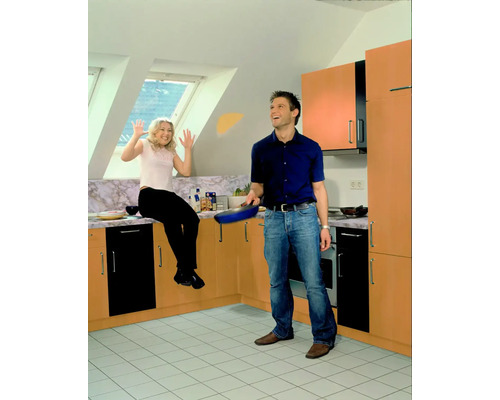 Lichte ruimte met koppel, man met koekenpan, vrouw zit op aanrecht.