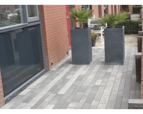 Buitenkant met planten in plantenbakken en straatstenen