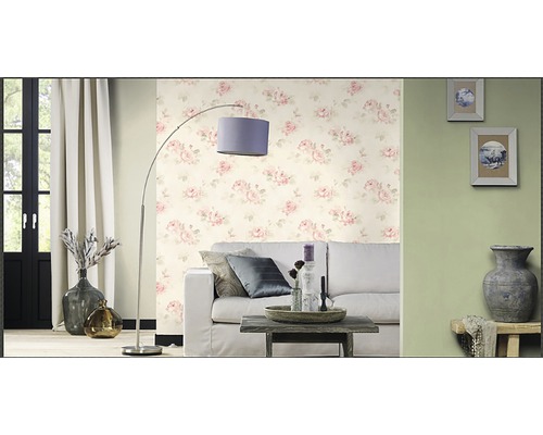 Woonkamer met bank, staande lamp en behang met bloemmotief