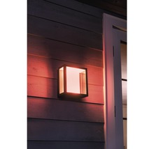 Verlichte, kubusvormige buitenwandlamp aan een huisgevel