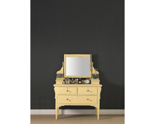 Gele kaptafel met spiegel en twee laden voor een donkere muur