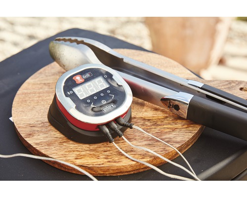 Weber iGrill Barbecue thermometer met barbecue tang op een houten plank