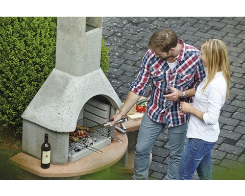 Gemetselde tuingrill met man en vrouw aan het barbecueën