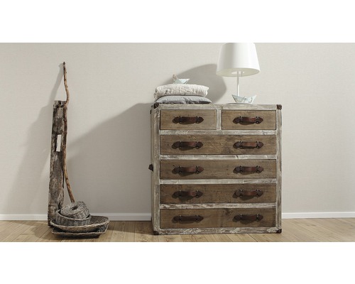 Ladekast, tafellamp en decoratie in een kamer