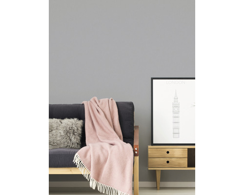 Woonkamer met bank, kussen, deken en bijzettafel met fotolijst