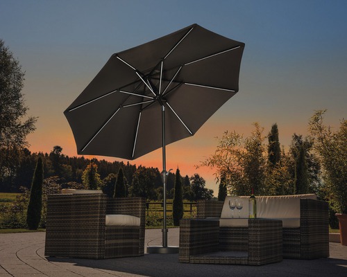 Scene met een tuinscherm met LED-verlichting en een zithoek op een terras.