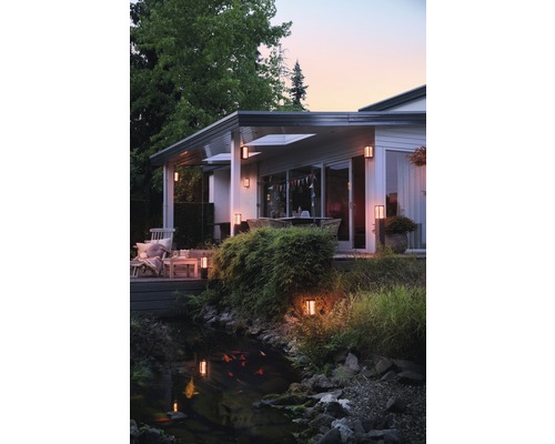 Buitenaanzicht van een huis met tuin, vijver en buitenverlichting