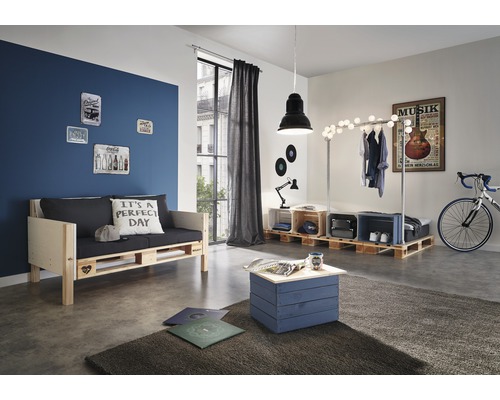 Woonkamer met meubels van pallets, waaronder een bank, een tafel en een kledingrek