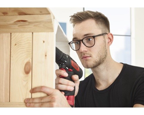 Man werkt met een accuschroevendraaier aan een houten plank