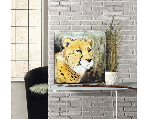 Decoratief schilderij met cheeta print op een ladekast, naast een potplant