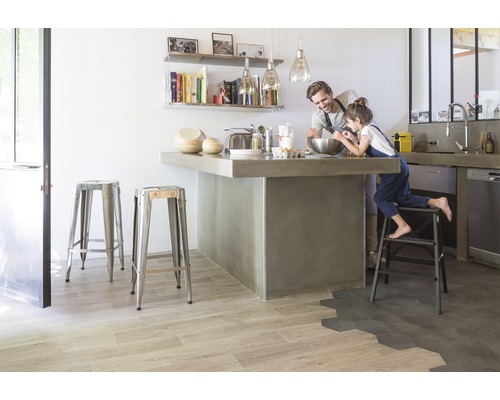 Lichte keuken met kookeiland, barkrukken en vader en kind aan het bakken.