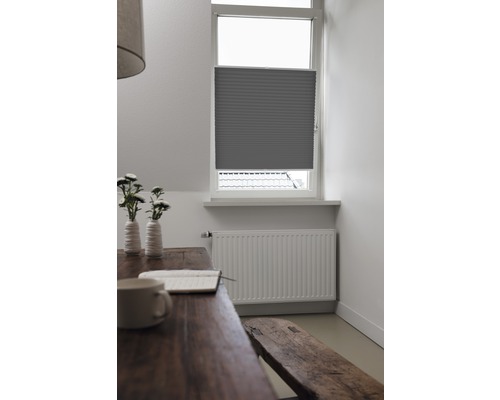 Interieurscène met tafel, bank, radiator en raam met plisségordijn