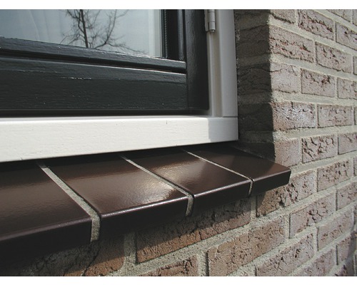 Close-up van een raam met vensterbank op een bakstenen muur