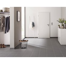 Hal met garderobe, deur, ladekast en grijze tegelvloer
