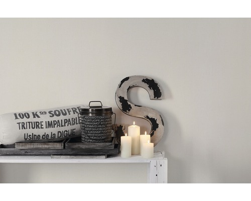 Decoratieve scène met kussen, blik, letter en kaarsen op een witte plank