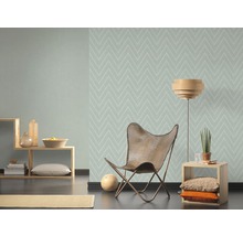 Woonkamer met patroonbehang, fauteuil en bijzettafel
